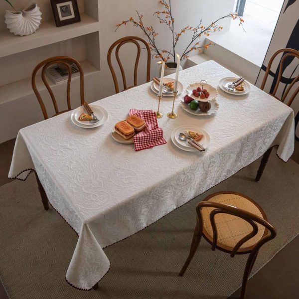 Embroidered cotton-blend tablecloth with scalloped shell edging, elegantly styled on a vintage dining table with natural light and classic tableware.