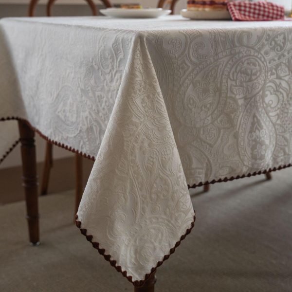 Embroidered cotton-blend tablecloth with scalloped shell edging, elegantly styled on a vintage dining table with natural light and classic tableware.