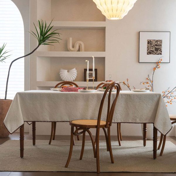Embroidered cotton-blend tablecloth with scalloped shell edging, elegantly styled on a vintage dining table with natural light and classic tableware.
