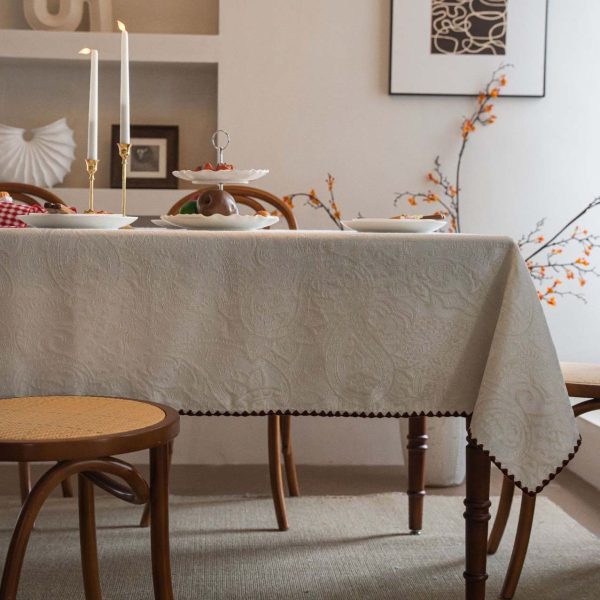 Embroidered cotton-blend tablecloth with scalloped shell edging, elegantly styled on a vintage dining table with natural light and classic tableware.
