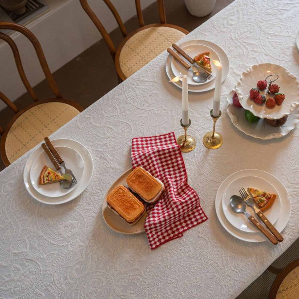 Embroidered cotton-blend tablecloth with scalloped shell edging, elegantly styled on a vintage dining table with natural light and classic tableware.