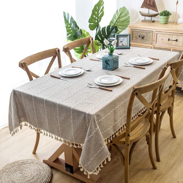 Beige faux linen tablecloth with white geometric embroidery and tassel fringe – perfect for modern dining rooms, cafés, or outdoor tables.