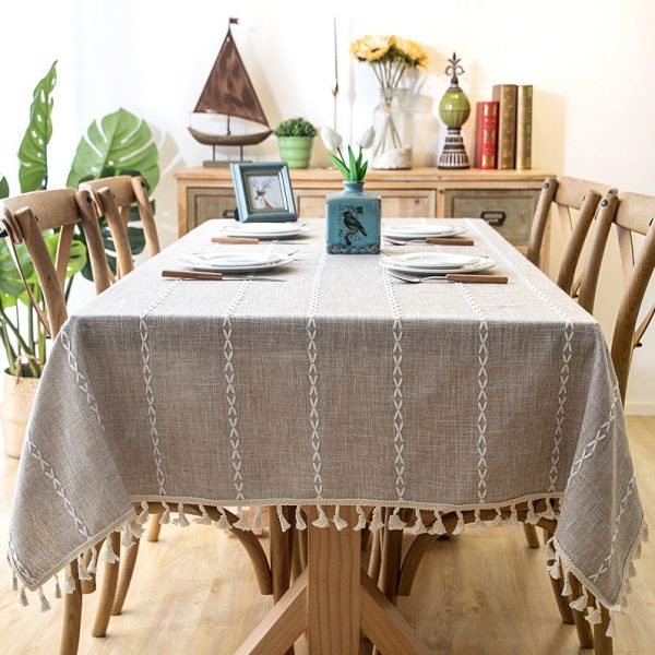 Beige faux linen tablecloth with white geometric embroidery and tassel fringe – perfect for modern dining rooms, cafés, or outdoor tables.