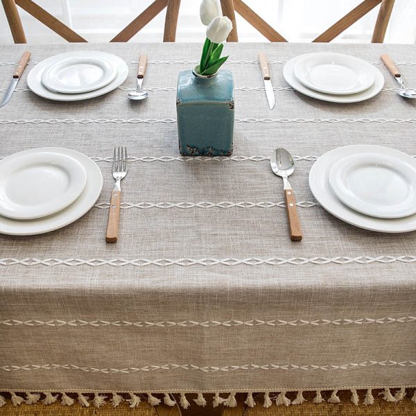 Beige faux linen tablecloth with white geometric embroidery and tassel fringe – perfect for modern dining rooms, cafés, or outdoor tables.