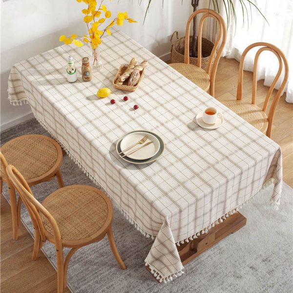 Brown plaid faux linen tablecloth with tassel trim styled on a farmhouse dining table
