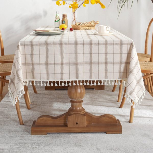 Brown plaid faux linen tablecloth with tassel trim styled on a farmhouse dining table