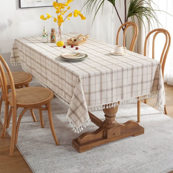 Brown plaid faux linen tablecloth with tassel trim styled on a farmhouse dining table