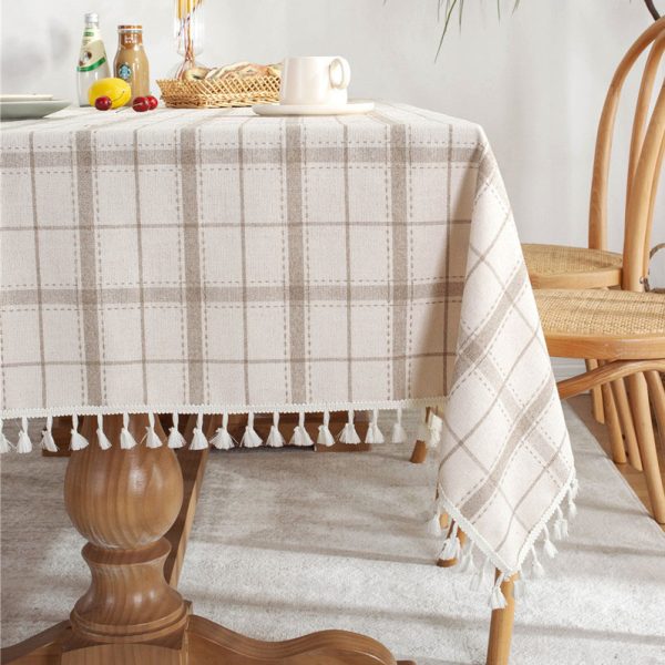 Brown plaid faux linen tablecloth with tassel trim styled on a farmhouse dining table