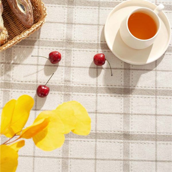 Brown plaid faux linen tablecloth with tassel trim styled on a farmhouse dining table