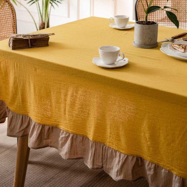Brighten your table with this cheerful yellow cotton tablecloth featuring soft ruffle trim. Farmhouse charm meets easy elegance. Machine washable and perfect for daily use.