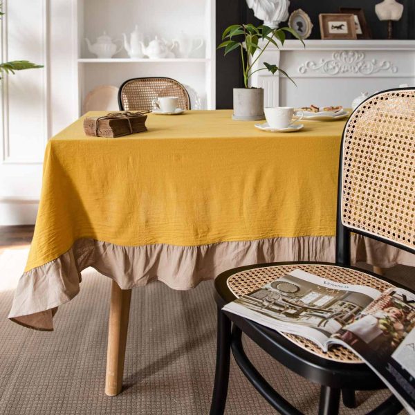 Brighten your table with this cheerful yellow cotton tablecloth featuring soft ruffle trim. Farmhouse charm meets easy elegance. Machine washable and perfect for daily use.