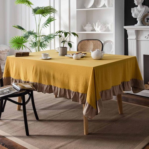 Brighten your table with this cheerful yellow cotton tablecloth featuring soft ruffle trim. Farmhouse charm meets easy elegance. Machine washable and perfect for daily use.