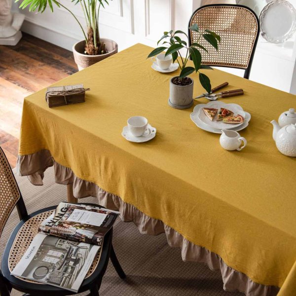 Brighten your table with this cheerful yellow cotton tablecloth featuring soft ruffle trim. Farmhouse charm meets easy elegance. Machine washable and perfect for daily use.