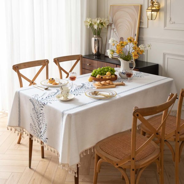 Dining table styled with Nordic-style embroidered tablecloth in soft beige and green tones