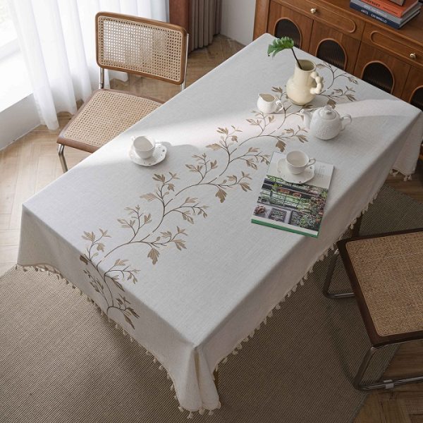 Picnic table set with beige reusable tablecloth under a tree