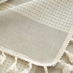 Close-up of neutral striped table linen texture and fringe edge