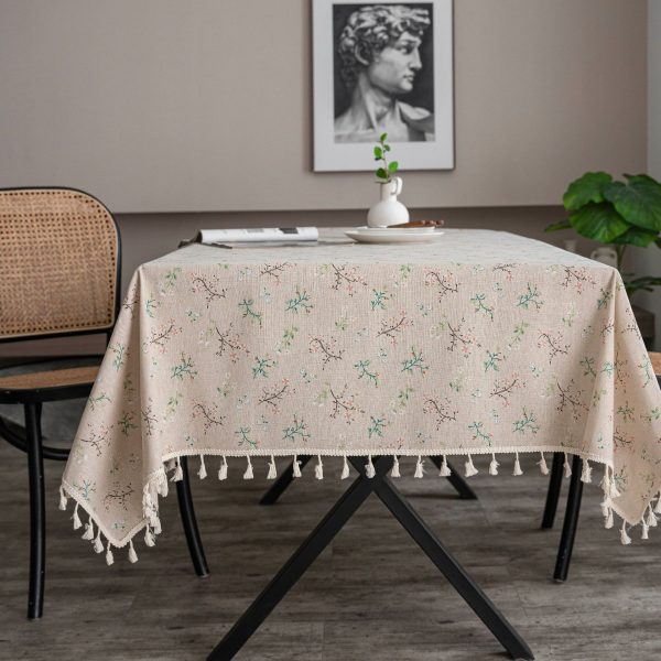 Vintage floral table linen with tassels on rustic wooden table