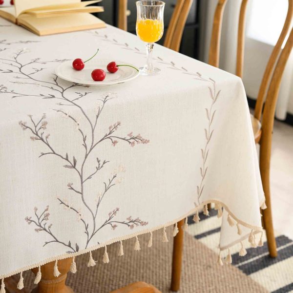 Lavender embroidered tablecloth with tassel fringe on wooden dining table