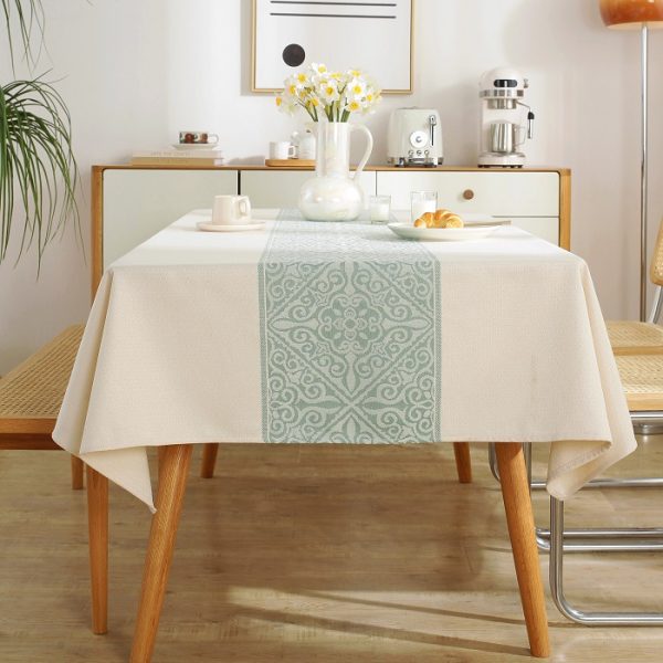 Elegant sage green embroidered faux linen tablecloth on a wood dining table