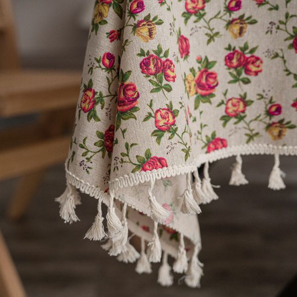 Outdoor picnic setup featuring floral table linens with vibrant rose designs