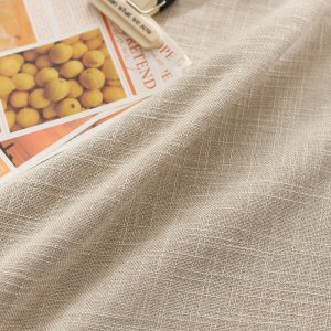 Close-up of textured cotton linen tablecloth in warm beige