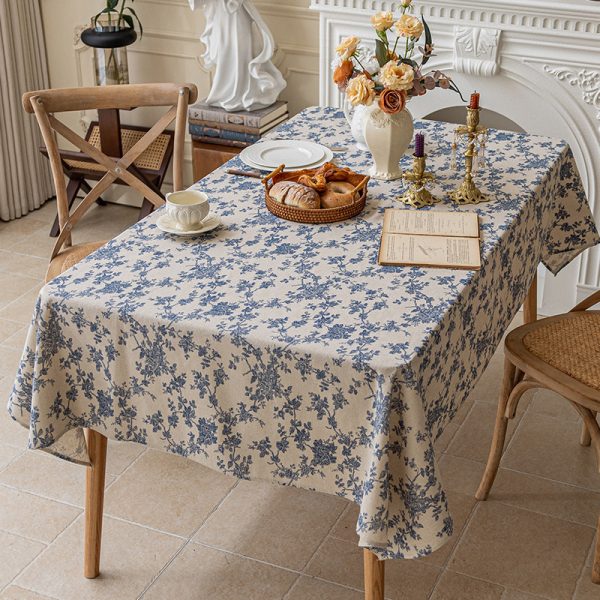 Vintage-style cotton linen tablecloth with blue floral print on a wooden dining table