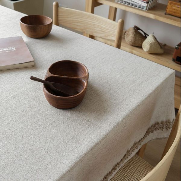 Vintage linen tablecloth with lace trim on wooden dining table